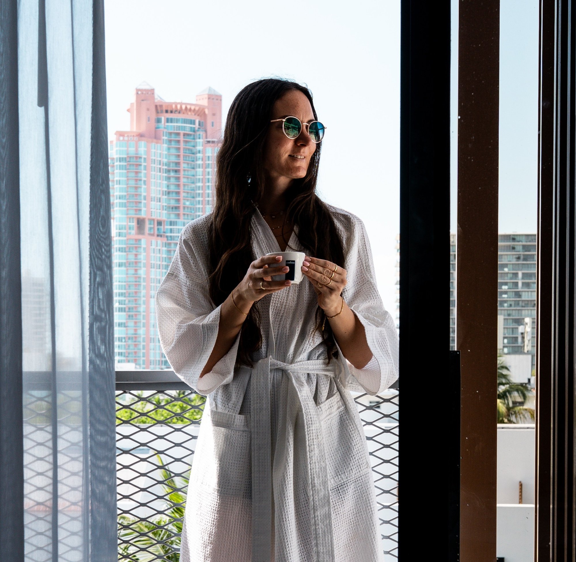 Girl having a cup of coffee in her room at the Upsun Hotel