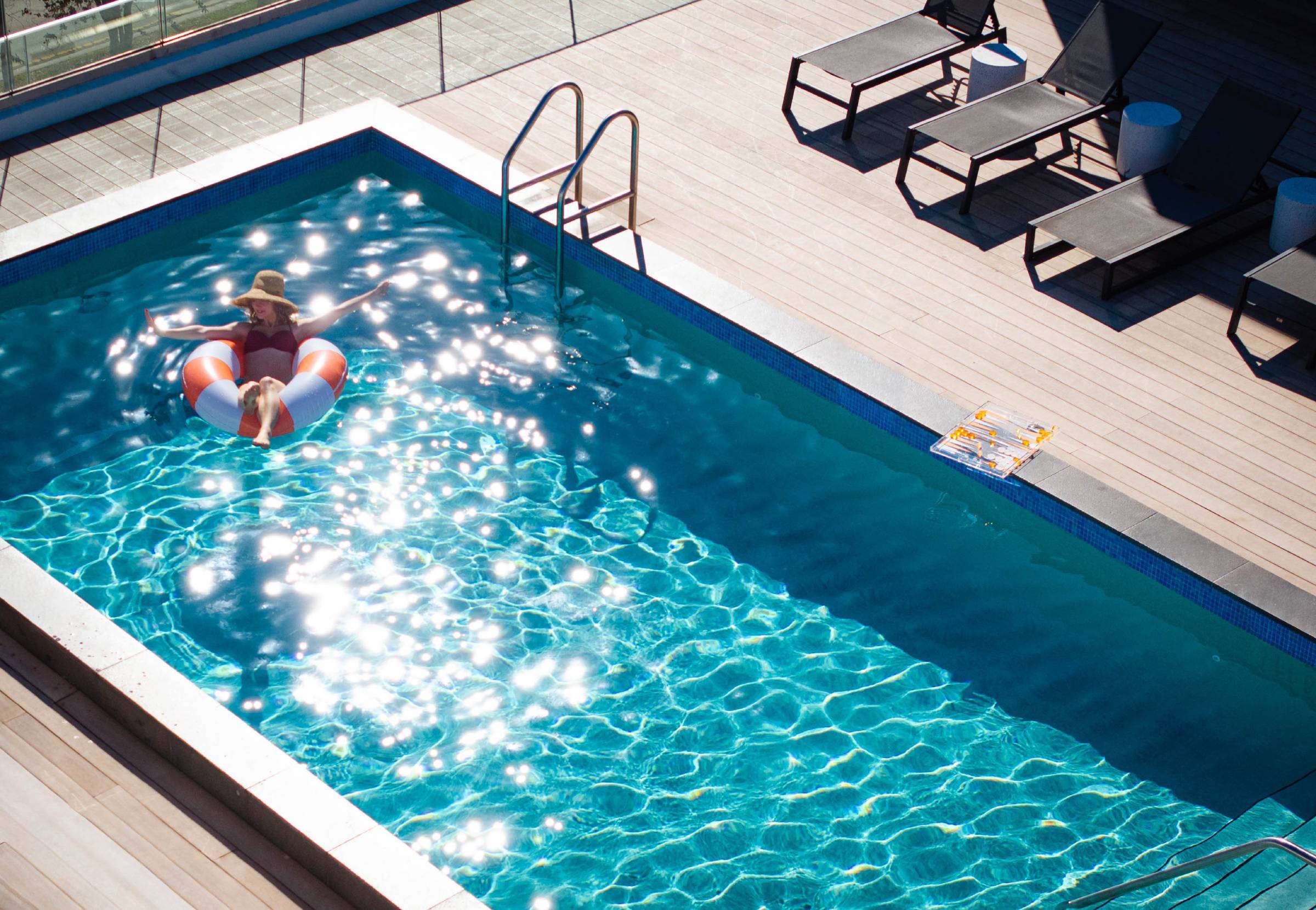 A woman enjoying the sun on the Upsun Hotel's rooftop pool
