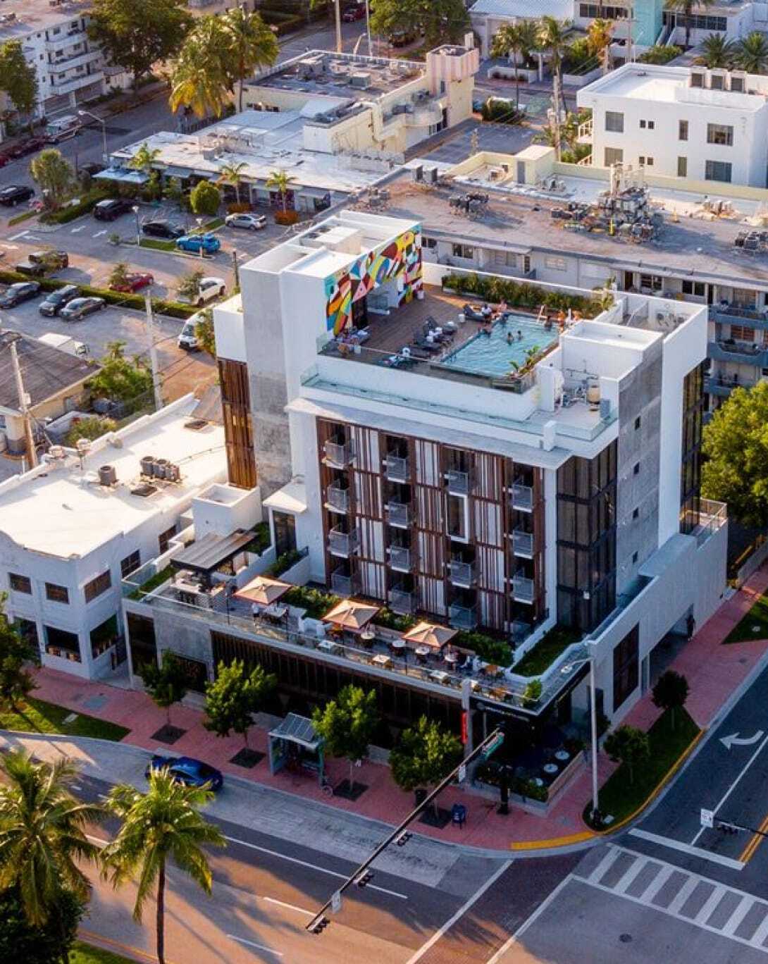 Aerial view of a modern hotel with a rooftop pool and terrace