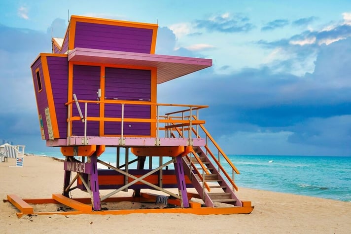 Vibrant lifeguard hut on Miami Beach with ocean view and cloudy sky backdrop