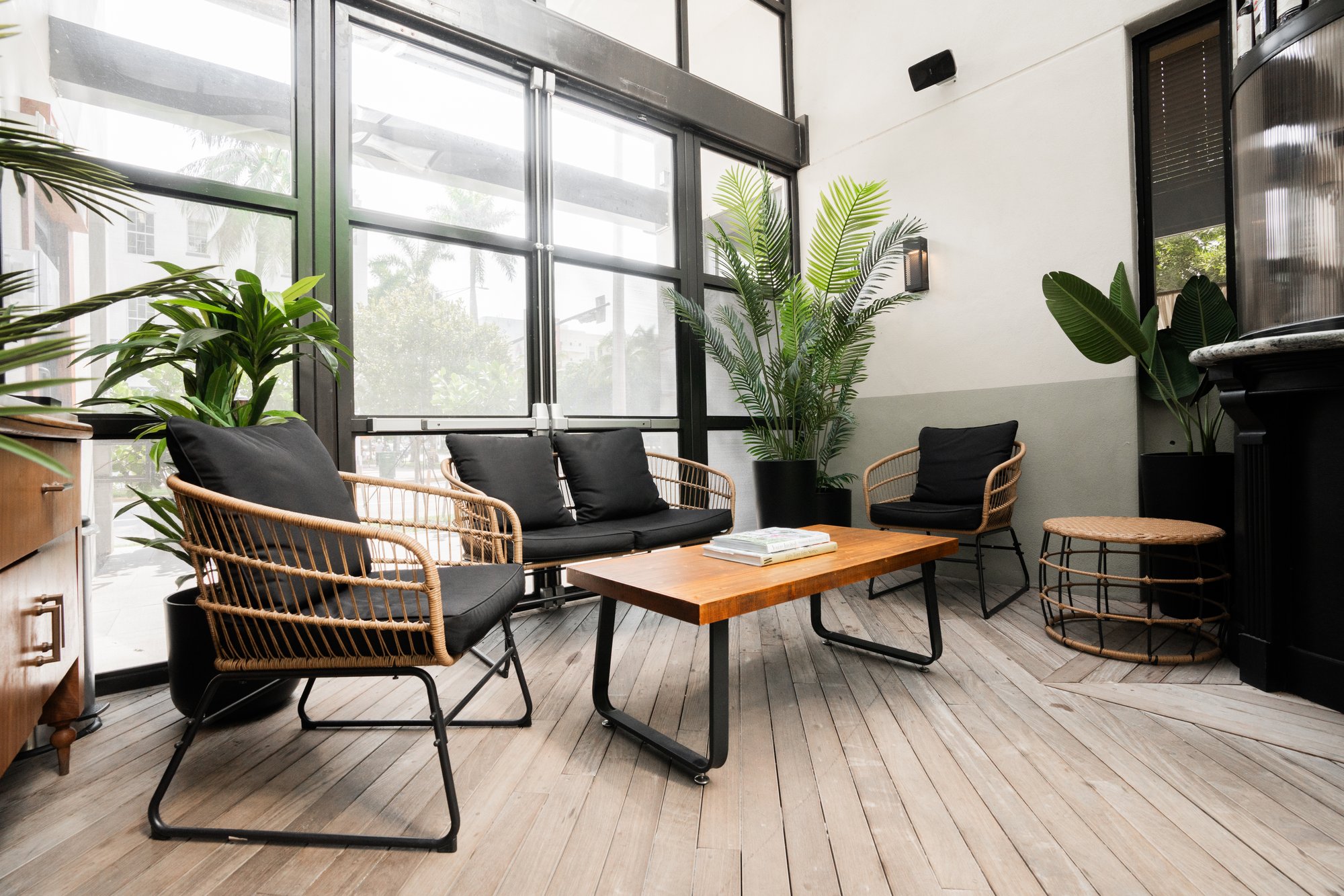 A modern lobby with a seating area, plants, and large windows.