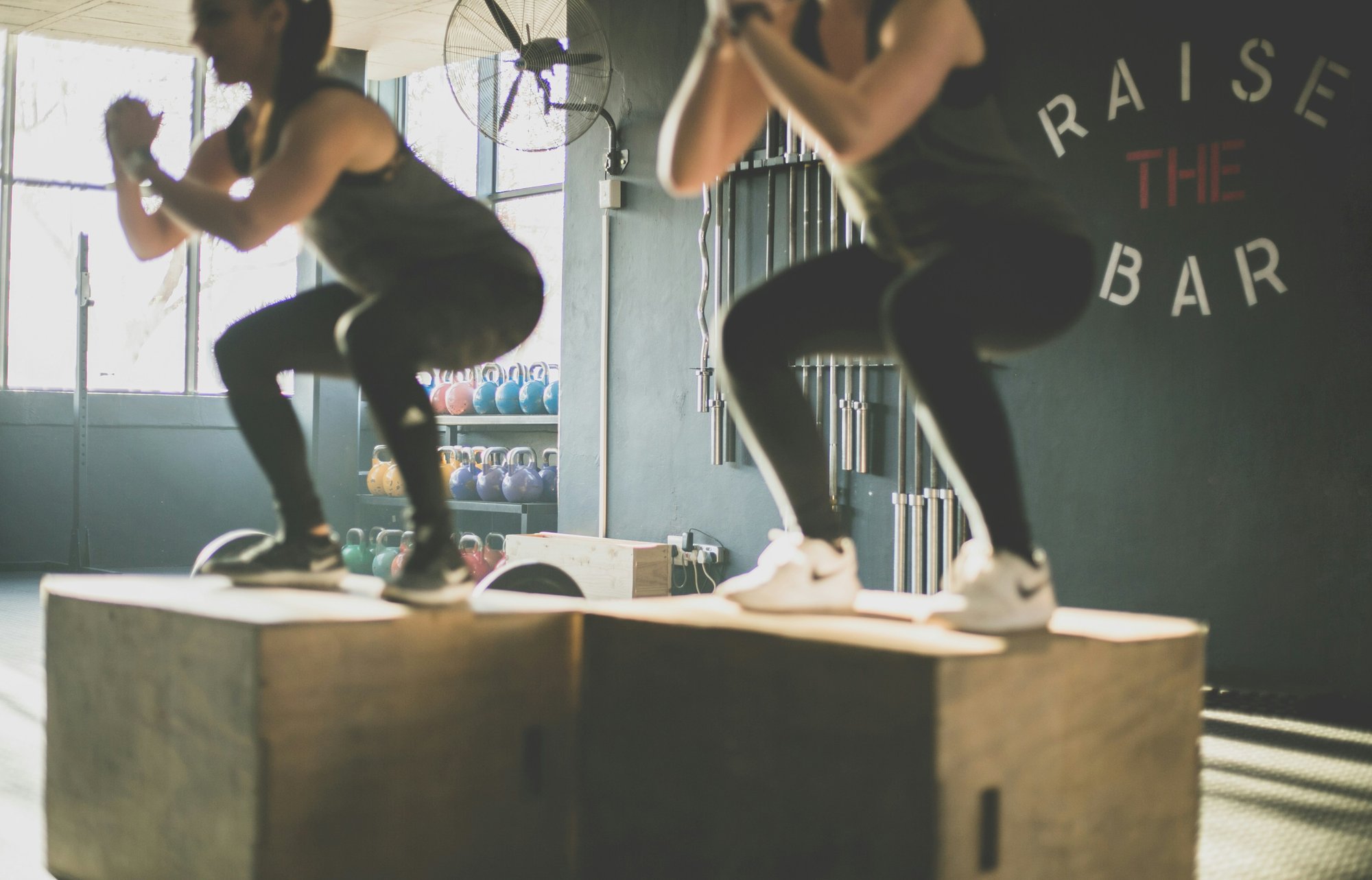 two women squatting in a gym