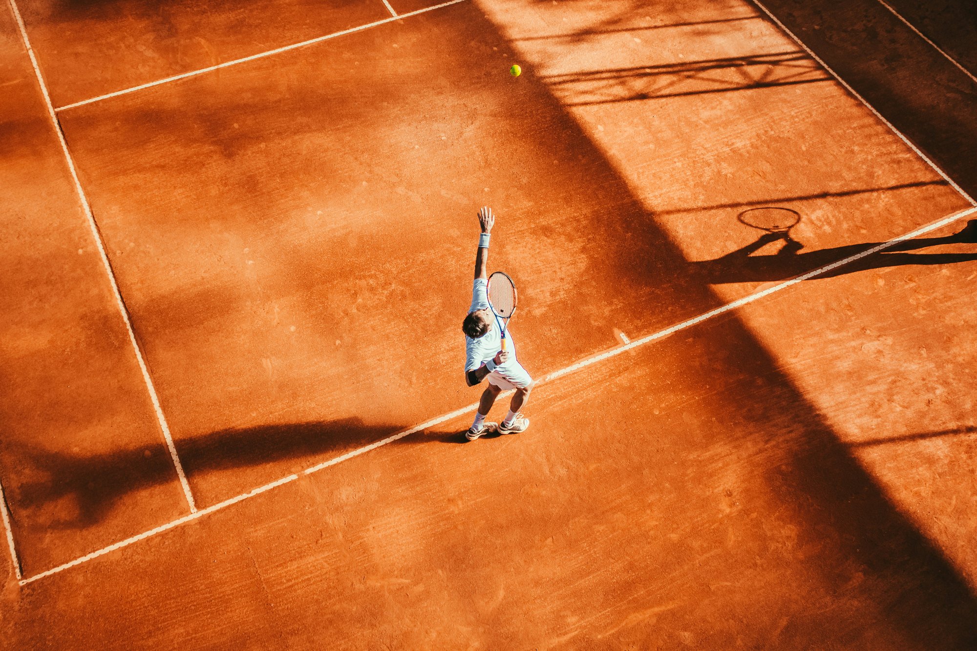 A man playing tennis on a clay court